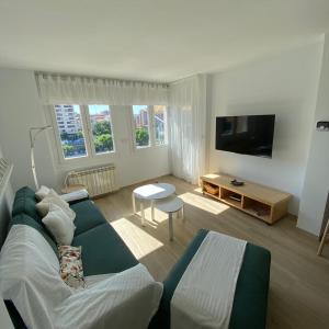 a living room with a couch and a tv at Apartamento completamente reformado en el casco antiguo con vistas al rio in Balaguer