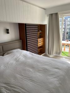ein Schlafzimmer mit einem weißen Bett und einem Fenster in der Unterkunft Madame Mouette in Blankenberge