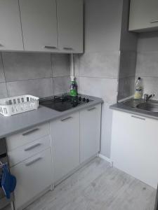 a small kitchen with white cabinets and a sink at Good Morning Podzamcze in Wałbrzych