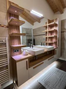 a bathroom with two sinks and a large mirror at Villa 22 in Oetz