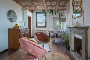 フィレンツェにあるVia Lamberti, 3 - Florence Charming Apartments - Charming and historic 5th-floor attic apartment with elevator in a building at the heart of vibrant Florence, just a 2-minute walk from all attractionsのリビングルーム(ピンクの椅子2脚、暖炉付)