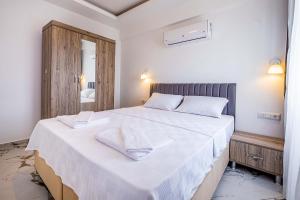 a bedroom with a large white bed with a mirror at Golden Rose Suit pension in Kaş