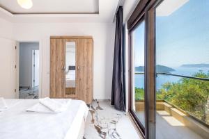 a bedroom with a bed and a large window at Golden Rose Suit pension in Kaş