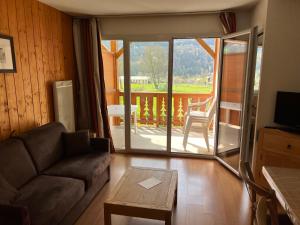 a living room with a couch and a sliding glass door at Loc luz st sauveur 5 in Luz-Saint-Sauveur