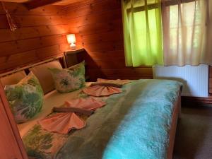 ein großes Bett mit Kissen darauf in einem Zimmer in der Unterkunft Naturpark Kanone in Markersdorf
