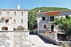 un antiguo edificio de piedra junto a una pared de piedra en Stonehouse dome Lagadia, en Lagadia