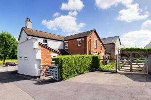 a brick house with a gate and a fence at Immaculate 6 Bed House with Unique Cellar Bar in Warminster