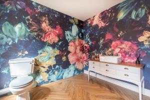 bagno con servizi igienici e carta da parati floreale di Immaculate 6 Bed House - Unique Cellar Bar- Airbnb a Warminster