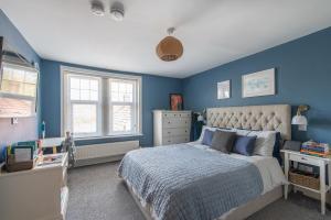 a bedroom with blue walls and a large bed at Immaculate 6 Bed House with Unique Cellar Bar in Warminster