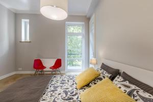 1 dormitorio con 1 cama y 2 sillas rojas en Nice Place, en Cracovia