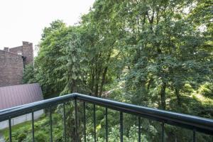 balcón con barandilla negra y árboles en Nice Place, en Cracovia