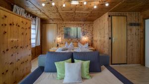 een slaapkamer met een bed met kussens erop bij Haus Egger in Kartitsch