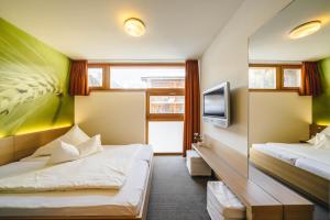 Habitación de hotel con 2 camas y TV en Smart-Hotel, en Samnaun