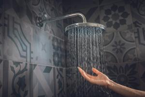 una persona se está lavando la mano bajo una ducha en Hotel Villa Alberta, en Nago-Torbole