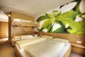a bedroom with two bunk beds and a plant mural at Smart-Hotel in Samnaun