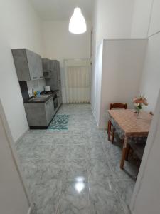 una cucina con tavolo, lavandino e piano cottura di Flegrei Apartment a Napoli