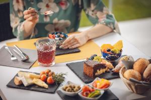 ein Tisch voller Essen und eine Person, die isst in der Unterkunft Boutique Hotel Villa Alberta in Nago-Torbole