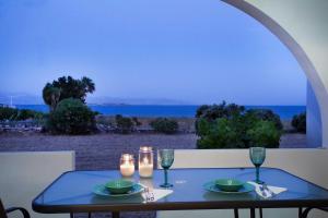 a table with two candles and a view of the ocean at Villa Zeta in Chrissi Akti