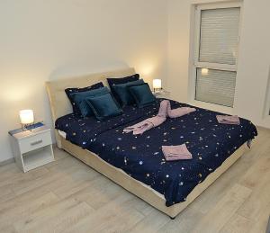 een slaapkamer met een bed met blauwe lakens en blauwe kussens bij Stan na dan Raška in Raška