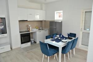una cucina con un tavolo bianco e sedie blu di Stan na dan Raška a Raška