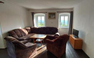 a living room with a couch and two chairs at Chalupa U Kolibříka in Želnava