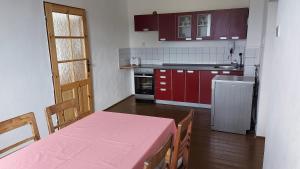 a kitchen with a table with a pink table cloth on it at Chalupa U Kolibříka in Želnava