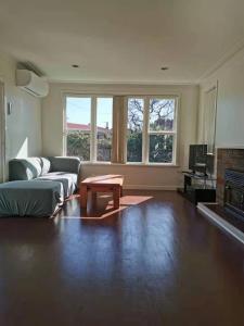 a living room with a couch and a coffee table at White weather board house in Auckland