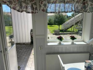 ein Zimmer mit einem Tisch und einem Fenster mit Blumen darauf in der Unterkunft Lärkan21 Tvisegatan 24C in Borlänge