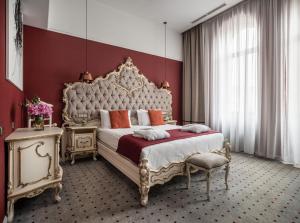 Grand Hotel Lviv Casino & Spa في إلفيف: غرفة نوم بسرير كبير وجدار احمر