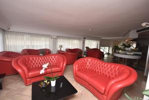 sala de estar con sillas rojas y mesa en Hotel Eden, en Bellaria-Igea Marina