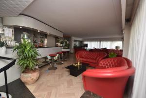 - un salon avec des chaises rouges et un bar dans l'établissement Hotel Eden, à Bellaria-Igea Marina