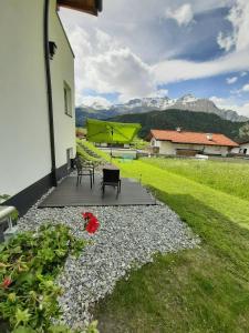 eine Terrasse mit 2 Stühlen und 2 Sonnenschirmen in der Unterkunft Apart Bergzeit in Nauders