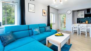 a blue couch in a living room with a table at Wonder Home - Apartament Blue z widokiem na góry - przy szlakach turystycznych i stokach narciarskich in Karpacz