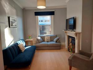 a living room with a blue couch and a fireplace at The York Riverside Suites in York