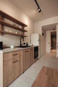 eine Küche mit Holzschränken und einem weißen Kühlschrank in der Unterkunft Om Living Afitos in Afytos + 150 Fotos