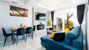 un soggiorno con divano blu e tavolo di Wonder Home - Apartamenty Blisko Gór - blisko szlaków turystycznych, wyciągów, restauracji, deptaka a Karpacz