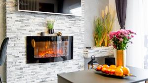 Una sala de estar con chimenea y una mesa. en Wonder Home - Apartamenty Blisko Gór - blisko szlaków turystycznych, wyciągów, restauracji, deptaka, en Karpacz