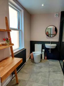 a bathroom with a toilet and a sink and a mirror at The York Riverside Suites in York
