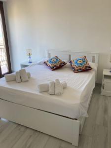 uma grande cama branca com duas almofadas em KROTONIATI APARTMENT em Crotone