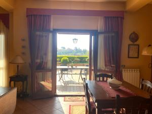 una sala da pranzo con porta che conduce a un patio di A casa di Tina a Mendicino