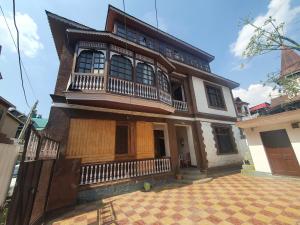 una vecchia casa con balcone su una strada di Hotel Wazir Palace a Srinagar