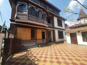 una casa antigua con un patio de azulejos frente a ella en Hotel Wazir Palace, en Srinagar