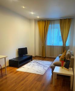 a living room with a couch and a tv at DMT Apartament Rin Grand in Bucharest