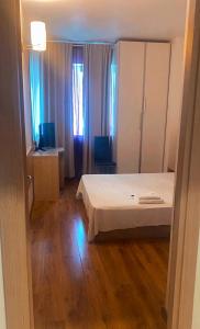 1 dormitorio con 1 cama y escritorio con TV en DMT Apartament Rin Grand en Bucarest