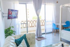 a living room with a couch and a balcony at SeaEsta studio Shanzu Serena in Mombasa