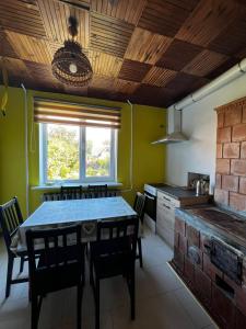 cocina con mesa, sillas y ventana en Liepājas brīvdienu māja ar dārzu, en Liepāja