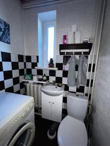 a bathroom with a white toilet and a sink at Liepājas brīvdienu māja ar dārzu in Liepāja