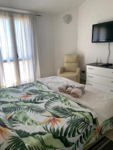 een slaapkamer met een bed, een stoel en een dressoir bij Villa Maria in Maracalagonis