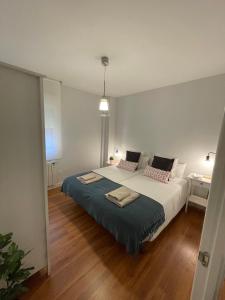 1 dormitorio con 1 cama grande con manta azul en Cuesta Del Cholo Cimadevilla en Gijón