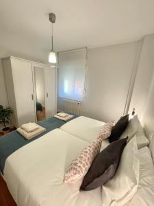1 dormitorio con 1 cama blanca grande con almohadas en Cuesta Del Cholo Cimadevilla en Gijón